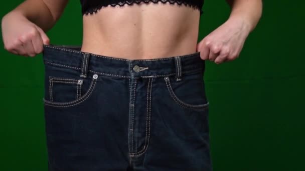 在大尺寸牛仔裤中减肥后 女性的腰围会变大 成功减肥 适当的营养 饮食和健康概念 纤细美丽的女性腹肌 穿着大裤子的瘦女人 — 图库视频影像