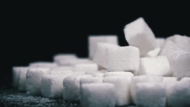 黒い背景に白砂糖のキューブの山 スイーツは健康に有害です 砂糖のコンセプトから生まれる 栄養とダイエットコントロール シュガーレス 糖尿病について スイーツからの体重増加 — ストック動画