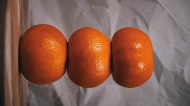 Üç Canlı Portakal 'ın yakın çekimi. Tarafsız bir arkaplana karşı, zengin dokularını ve renklerini vurgulayan bir portakal üçlüsü sergiliyor