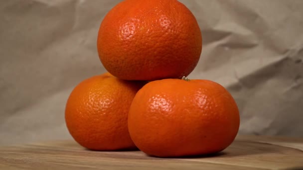 3つの新鮮なオレンジの芸術的な配置は 素朴な背景に対してオレンジのトリオを展示し その鮮やかな色と質感を強調しています — ストック動画