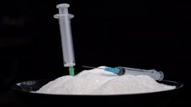 Şırınga şekerli bir tabağa düşer, şeker bağımlılığı. Tatlılar sağlığa zararlıdır. Şeker bağımlılığı. Beslenme ve diyet kontrolü. Şekersiz. Diyabet. Tatlıdan kilo alma.