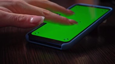 Kadın krom anahtarı olan yeşil ekranlı akıllı telefon kullanıyor. Sosyal ağlara veya çevrimiçi mağazalara göz atın - İnternet, yakın çekim iletişim kavramı.