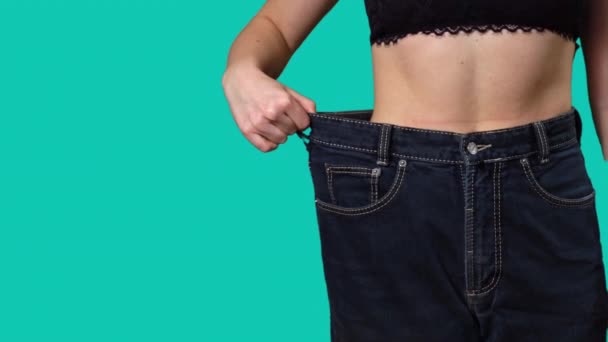 女性は大きなサイズのジーンズコピースペースで体重を減らした後ウエストします 成功した体重減少 適切な栄養 そして健康の概念 スリムな美しい女性の不在 大きなズボンの薄い女性 — ストック動画