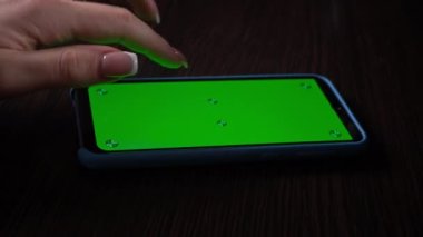 Kadın krom anahtarı olan yeşil ekranlı akıllı telefon kullanıyor. Sosyal ağlara veya çevrimiçi mağazalara göz atın - İnternet, yakın çekim iletişim kavramı.