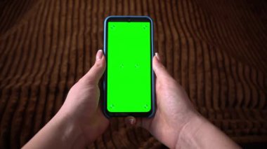 İnsanlar krom anahtarı olan yeşil ekranlı akıllı telefon kullanırlar. Sosyal ağlara veya çevrimiçi mağazalara göz atın - İnternet, yakın çekim iletişim kavramı.