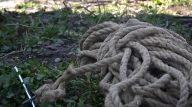 Balta çimenlerin üzerinde ve yakınlarda bir ip var. Ağaçları kesmek, dalları kesmek..