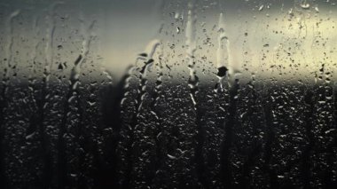 Sabahın erken saatlerinde yağmur lekeli camların arasından süzülür. Fırtına dinerken açık gökyüzü vaadi.