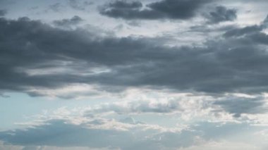 Beyaz kabarık bulutlar mavi gündüz vakti gökyüzünde yavaşça süzülür. Güzel gökyüzü hareket ediyor. Kar beyazı bulutlar yana doğru hareket ediyor..