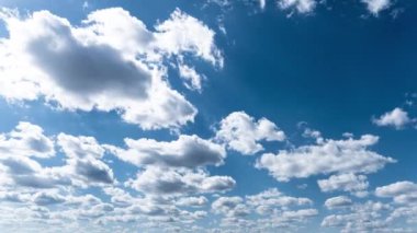 Beyaz kabarık bulutlar mavi gündüz vakti gökyüzünde yavaşça süzülür. Güzel gökyüzü hareket ediyor. Kar beyazı bulutlar yana doğru hareket ediyor..