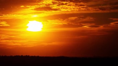 Bulutlu bir gökyüzünde gün batımında turuncu altın güneş. Güneşin doğuşunun ya da batışının altın saatinde gökyüzüne karşı bulutlar. Günün güzel gün batımı.