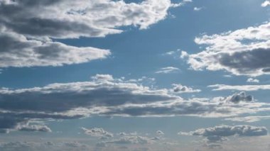Beyaz kabarık bulutlar mavi gündüz vakti gökyüzünde yavaşça süzülür. Güzel gökyüzü hareket ediyor. Kar beyazı bulutlar yana doğru hareket ediyor..