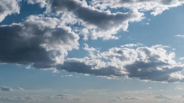 Beyaz kabarık bulutlar mavi gündüz vakti gökyüzünde yavaşça süzülür. Güzel gökyüzü hareket ediyor. Kar beyazı bulutlar yana doğru hareket ediyor..