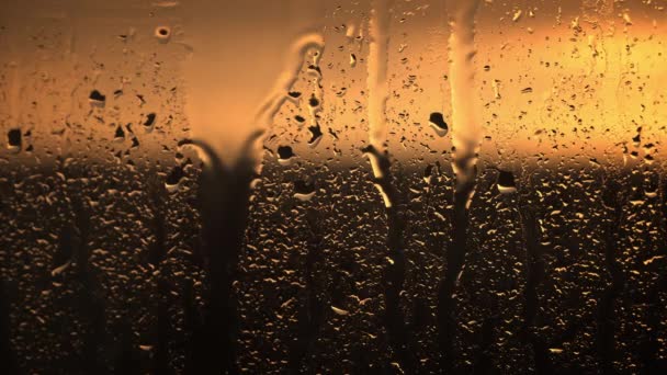 日没の激しいオレンジは 窓に美しくエフェクトなアートワークをキャスティングし 雨滴でモザイクを作成します — ストック動画