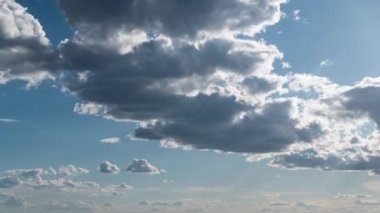 Beyaz kabarık bulutlar mavi gündüz vakti gökyüzünde yavaşça süzülür. Güzel gökyüzü hareket ediyor. Kar beyazı bulutlar yana doğru hareket ediyor..