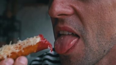 Adam ketçaplı kızarmış peynirli atıştırmalıktan bir ısırık alıyor..