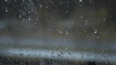 Pencerede yağmur damlaları ve su izleri bulanık bir arka plan etkisi yaratır. Videonuza derinlik ve atmosfer eklemek için bunu kullanın.