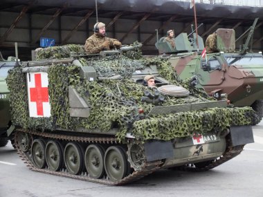 Letonya Ulusal Silahlı Kuvvetleri 'nin Riga' daki geçit töreni Daugava seti üzerinde. Törene Arnavutluk, İzlanda, İspanya, İtalya, Kanada, Litvanya, Polonya, Slovakya, Slovenya, ABD, Karadağ ve Çek Cumhuriyeti 'nden askeri personel katıldı.