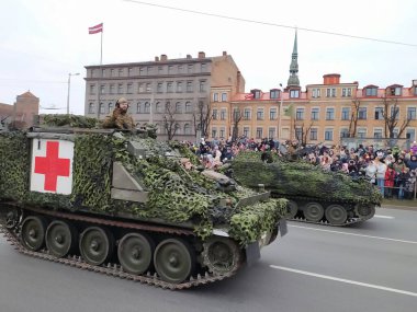 Letonya Ulusal Silahlı Kuvvetleri 'nin Riga' daki geçit töreni Daugava seti üzerinde. Törene Arnavutluk, İzlanda, İspanya, İtalya, Kanada, Litvanya, Polonya, Slovakya, Slovenya, ABD, Karadağ ve Çek Cumhuriyeti 'nden askeri personel katıldı.