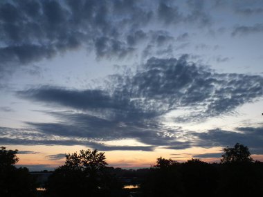 Riga 'nın Bolderaja bölgesinde günbatımında alışılmadık şekillerde bulutlar.