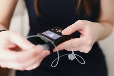 Kadın insülin pompasına dolu bir su deposu yerleştiriyor.