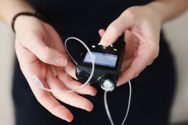 Kadın insülin pompasına dolu bir su deposu yerleştiriyor.