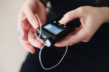 İnsülin pompasını elinde tutan kadın