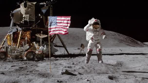 アメリカの国旗と宇宙船の近くで月の表面に飛び込む宇宙飛行士 月の風景にある宇宙飛行士 宇宙探査コンセプト Nasaの画像で作られたアニメーション — ストック動画