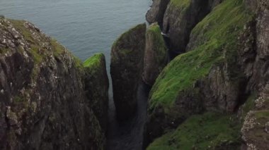 Faroe Adaları, Dunnesdrangar 'ın insansız hava aracı görüntüsü. İnanılmaz doğa, Faroe Adaları 'ndaki büyük kayalıklar ve dağlar. Vagar Adası. Bir sürü uçan deniz kuşu. Yazın güneşli bir gün. Yüksek kalite 4k görüntü. 