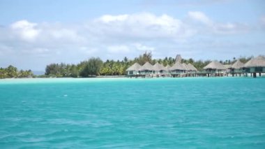 Turquoise blue lagoon in Bora Bora, Tahiti, French Polynesia. Cruising on a yacht around Bora Bora with a view of water villas. Luxury travel vacation, romantic getaway, honeymoon exotic destination
