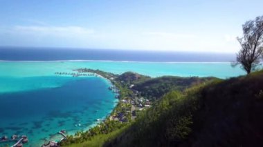 Yeşil tepeler, doğa, turkuaz plaj ve Bora Bora, Tahiti 'deki mavi lagünün 4K hava aracı görüntüleri, Fransız Polinezyası. Lüks, romantik tatil, balayı için egzotik bir yer..
