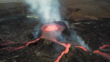 Geldingadalir, Reykjanes, İzlanda 'daki Fagradalsjall volkanik patlamasının 4K hava aracı görüntüleri. Sıcak Lav Nehri dumanla çevrili tepeden aşağı akıyor. İzlanda Volkanik Patlaması Grindavik