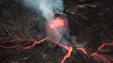 Geldingadalir, Reykjanes, İzlanda 'daki Fagradalsjall volkanik patlamasının 4K hava aracı görüntüleri. Sıcak Lav Nehri dumanla çevrili tepeden aşağı akıyor. İzlanda Volkanik Patlaması Grindavik