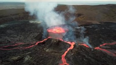 Geldingadalir, Reykjanes, İzlanda 'daki Fagradalsjall volkanik patlamasının 4K hava aracı görüntüleri. Sıcak Lav Nehri dumanla çevrili tepeden aşağı akıyor. İzlanda Volkanik Patlaması Grindavik