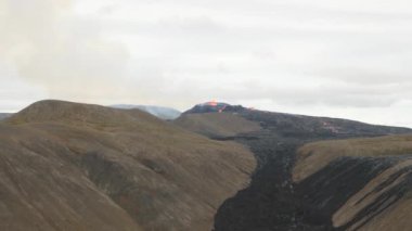 4K footage of Fagradalsfjall active volcano eruption in Geldingadalir, Reykjanes, Iceland. River Of Hot Lava Flowing down the hill surrounded by smoke. Iceland Volcanic eruption Grindavik