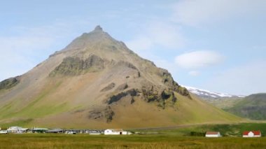 İzlanda 'daki Arnarstapi köyü. İzlanda 'da dağlar ve buzullar. Snaefellsjokull arkada. Yüksek kalite 4K görüntü. Stapafell Dağı ve Snaefellsjokull Buzulu.