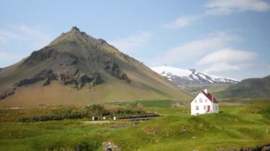 Arnarstapi village in Iceland. Small white church with huge moutains in the back. High quality 4k footage. Stapafell mountain and Snaefellsjokull glacier.
