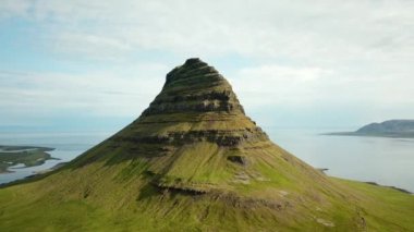 Aerial drone footage of an Icelandic green nature around Kirkjufell mountain in the snaefellsnes peninsula, during summer. High quality 4k footage