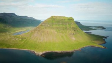 Aerial drone footage of an Icelandic green nature around Kirkjufell mountain in the snaefellsnes peninsula, during summer. High quality 4k footage