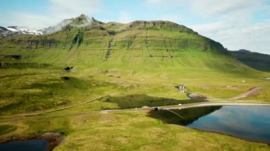 Aerial drone footage of an Icelandic green nature around Kirkjufell mountain in the snaefellsnes peninsula, during summer. High quality 4k footage