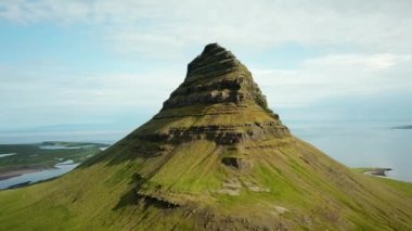 Aerial drone footage of an Icelandic green nature around Kirkjufell mountain in the snaefellsnes peninsula, during summer. High quality 4k footage