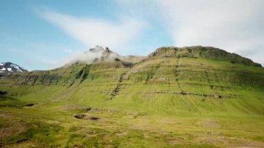 Aerial drone footage of an Icelandic green nature around Kirkjufell mountain in the snaefellsnes peninsula, during summer. High quality 4k footage