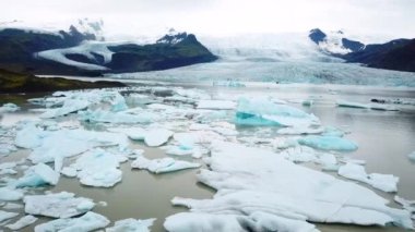 Aerial drone footage of Fjallsarlon glacier lagoon with plenty of icebergs floating in a lake, Iceland. Scenic view of Ice bergs. Artic nature ice landscape. Melting glacier in Iceland. Climate change