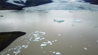 Aerial drone footage of Fjallsarlon glacier lagoon with plenty of icebergs floating in a lake, Iceland. Scenic view of Ice bergs. Artic nature ice landscape. Melting glacier in Iceland. Climate change