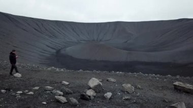 İzlanda 'da aktif olmayan bir Hverfjall yanardağının insansız hava aracı görüntüleri. İzlanda 'da hareketsiz bir volkan olan Hverfjall kraterinin sinematik hava görüntüsü. Volkanın içindeki adam. Yüksek kalite 4k görüntü