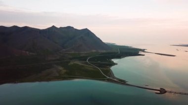 Yazın günbatımında Hofn yakınlarında Bodvegur köprüsü etrafında deniz bulunan İzlanda 'nın yeşil doğasına ait hava aracı görüntüleri. Yüksek kalite 4k görüntü