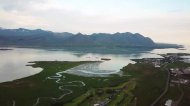 Yazın günbatımında Hofn yakınlarında Bodvegur köprüsü etrafında deniz bulunan İzlanda 'nın yeşil doğasına ait hava aracı görüntüleri. Yüksek kalite 4k görüntü