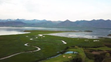 Yazın günbatımında Hofn yakınlarında Bodvegur köprüsü etrafında deniz bulunan İzlanda 'nın yeşil doğasına ait hava aracı görüntüleri. Yüksek kalite 4k görüntü