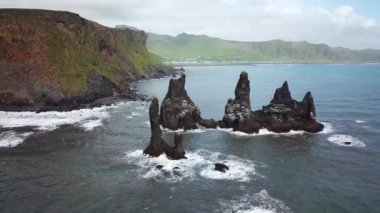 İzlanda 'daki Vik yakınlarında Reynisfjara Sahili' nde okyanustan sarkan Sivri kayaların hava aracı görüntüleri. Siyah kumsal yakınlarındaki Sivri Kaya kayalıkları. Yüksek kalite 4k görüntü