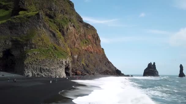 アイスランドのヴィク近くのレイニスフィヤラビーチで 海から突き出たポインティ岩の空中ドローン映像 黒砂のビーチでポティロック崖 玄武岩列と玄武岩の洞窟 高品質4K映像 — ストック動画