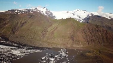 Vatnajokull 'un buz dilinin hava aracı görüntüleri. Buzdağlarıyla buzdağları buzul gölünde yüzen Skaftafell buzulu. Vatnajokull 'un manzarası. Artistik buz tabakası. İzlanda 'da eriyen buzullar.